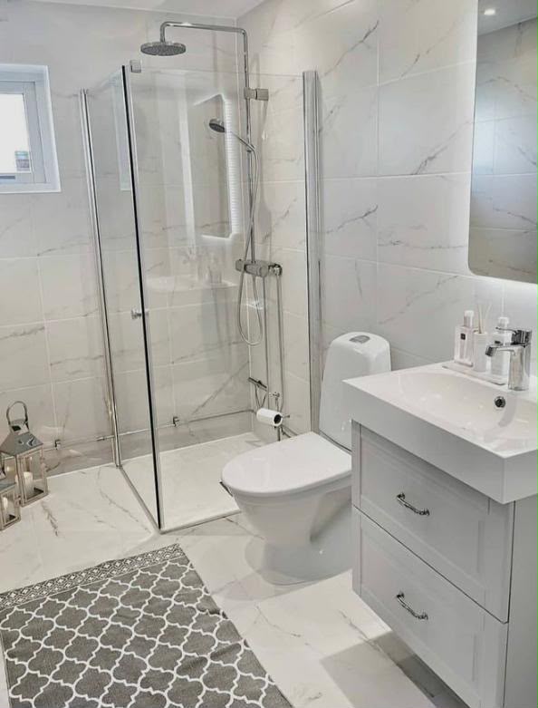 Finished bathroom remodel with walk-in glass shower and new vanity unit